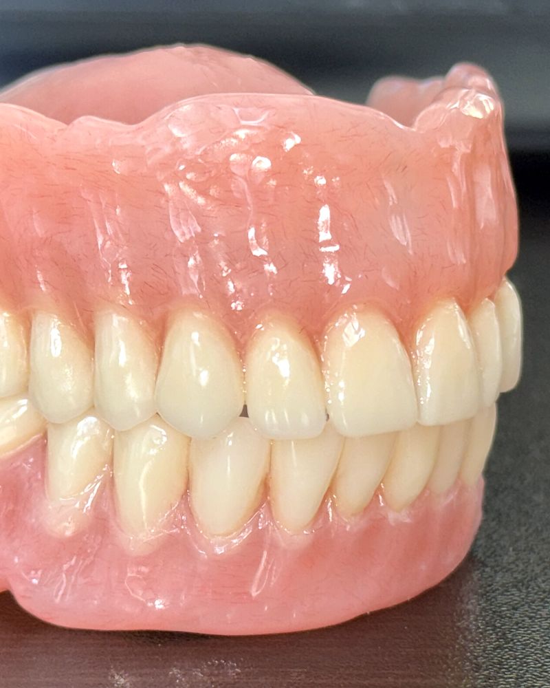 Complete upper and lower dentures with pink acrylic bases